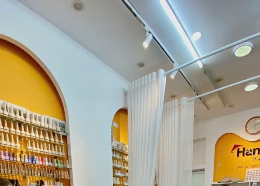 Nội thất tiệm Hanoi Nail & Lash sáng và hiện đại tại Hà Nội, Hà Nội, VN với dãy sơn đa sắc.