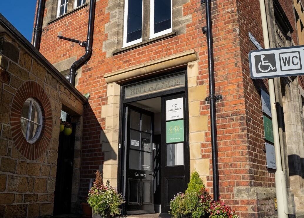 Entrance of Beauty By Lexie Louise, Scarborough, GB with brick facade and potted plants.