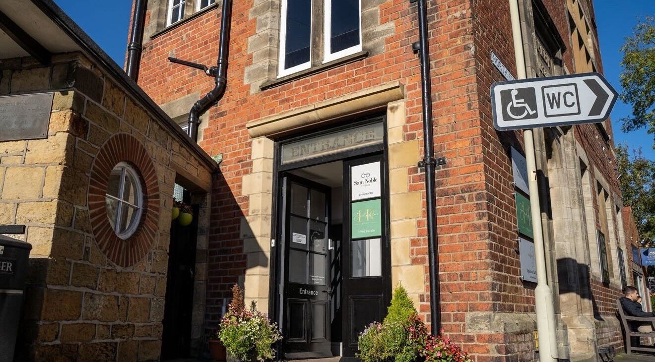 Entrance of Beauty By Lexie Louise, Scarborough, GB with brick facade and potted plants.