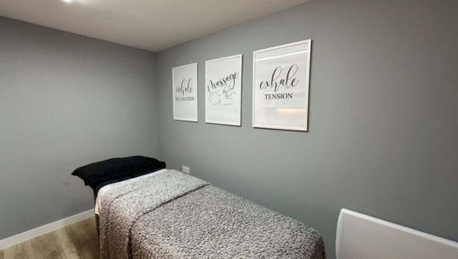Calm treatment room in Elle Aesthetic, London, England, GB with soothing wall art and massage bed.