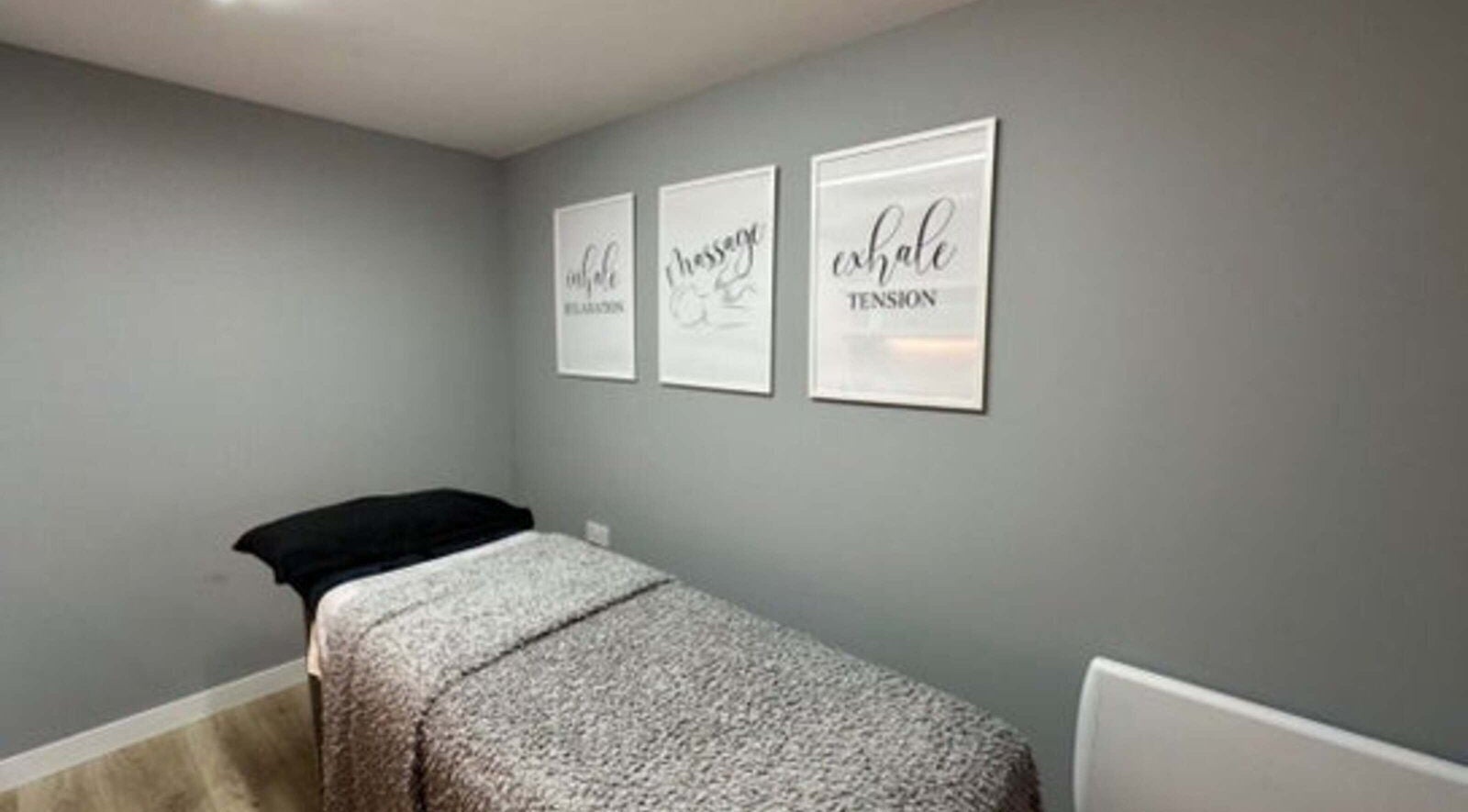 Calm treatment room in Elle Aesthetic, London, England, GB with soothing wall art and massage bed.