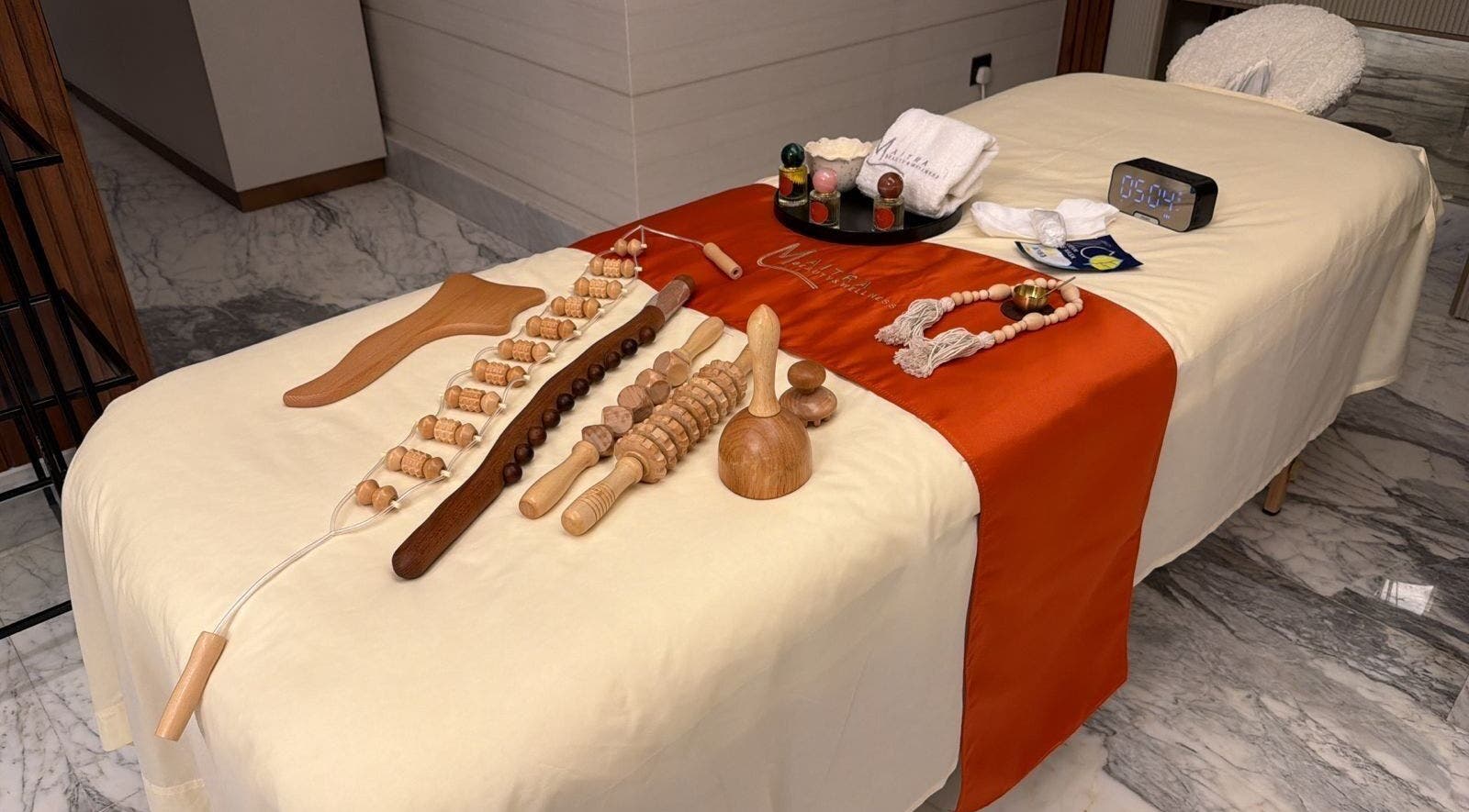 أدوات تدليك خشبية على طاولة في Maitra Spa بالرياض، SA لجلسة تدليك مريحة.