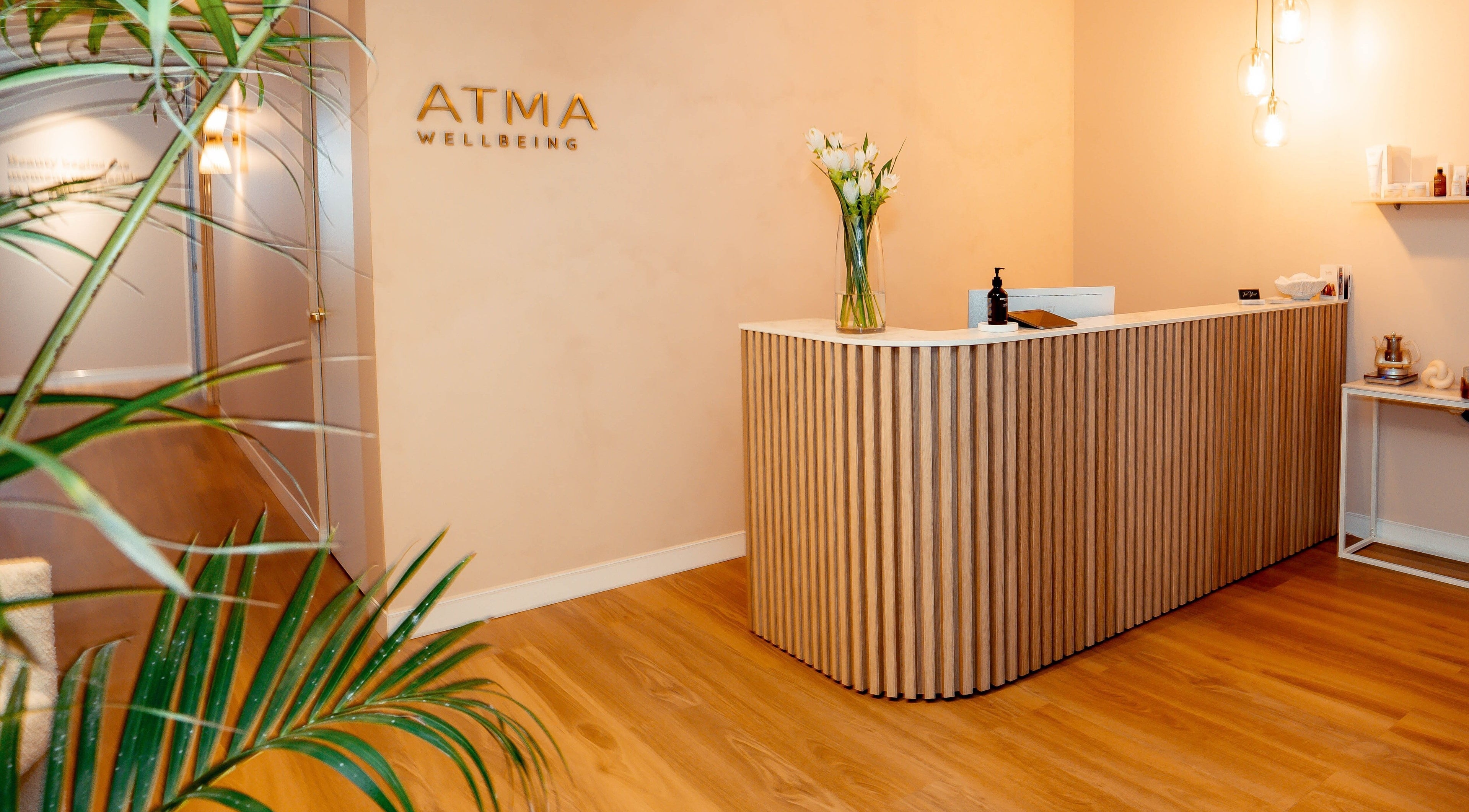 Reception area of Atma Wellbeing in Dee Why, New South Wales, AU, featuring a modern wooden desk and decor.