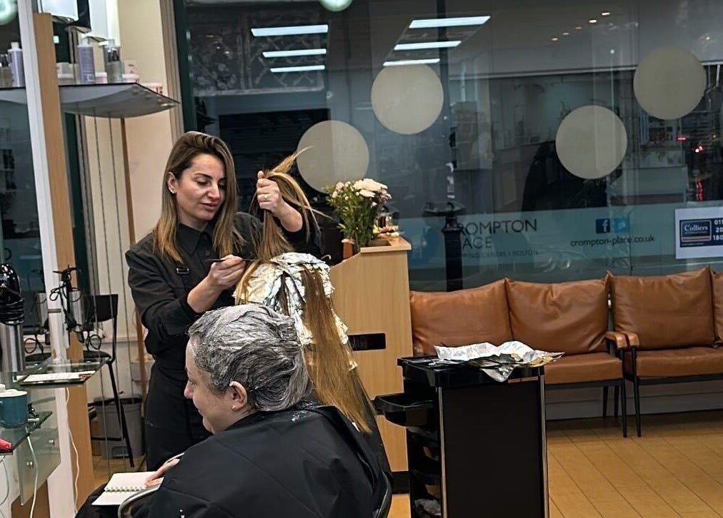 Stylist coloring hair at Glam Hair Salon, Bolton, England, GB, showcasing expert care and comfort.