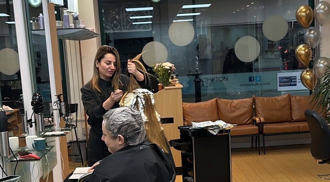 Stylist coloring hair at Glam Hair Salon, Bolton, England, GB, showcasing expert care and comfort.