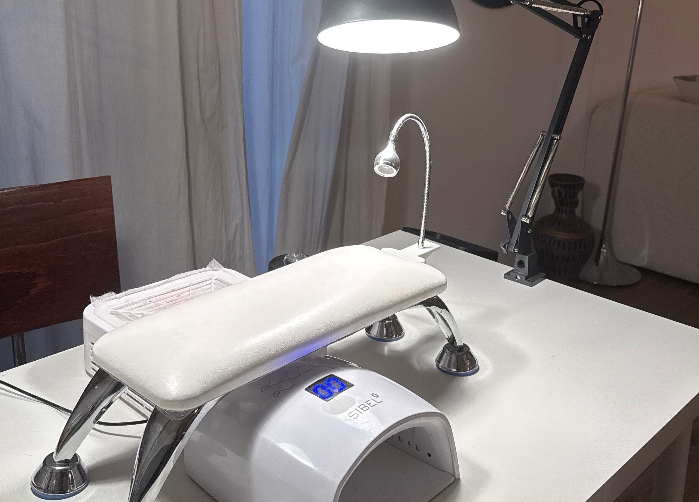 Table de manucure à Bizznails, Ambérieu-en-Bugey, Auvergne-Rhône-Alpes, FR, éclairée par une lampe moderne.