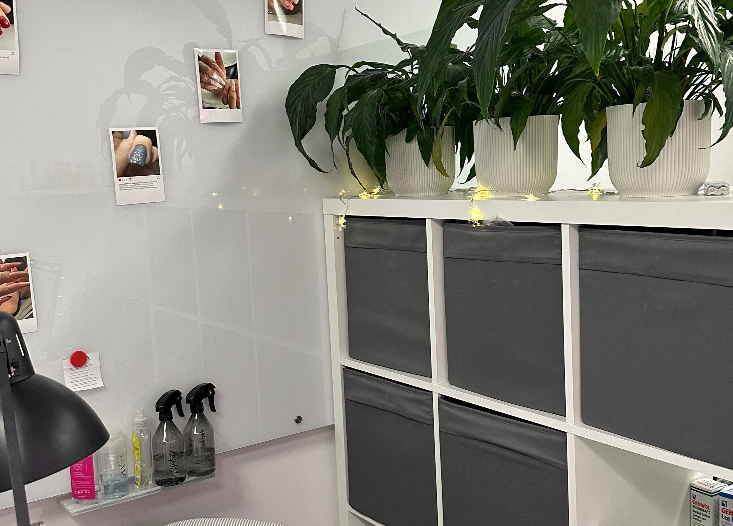 Mango Beauty Studio in Woking, England, GB, features a stylish nail art display and lush plants.