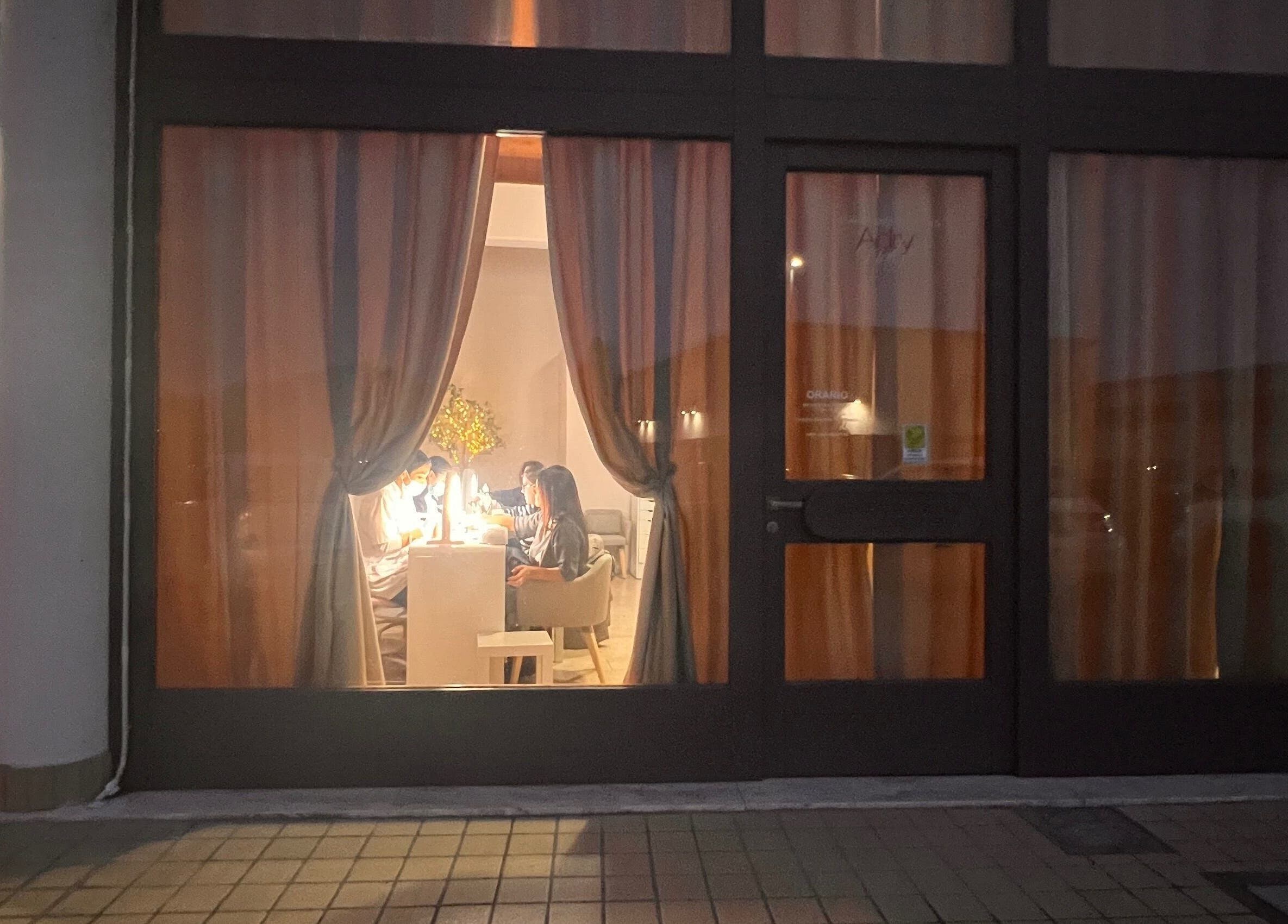 Visuale notturna di Adry Nails a L'aquila, Abruzzo, IT, con clienti all'interno.