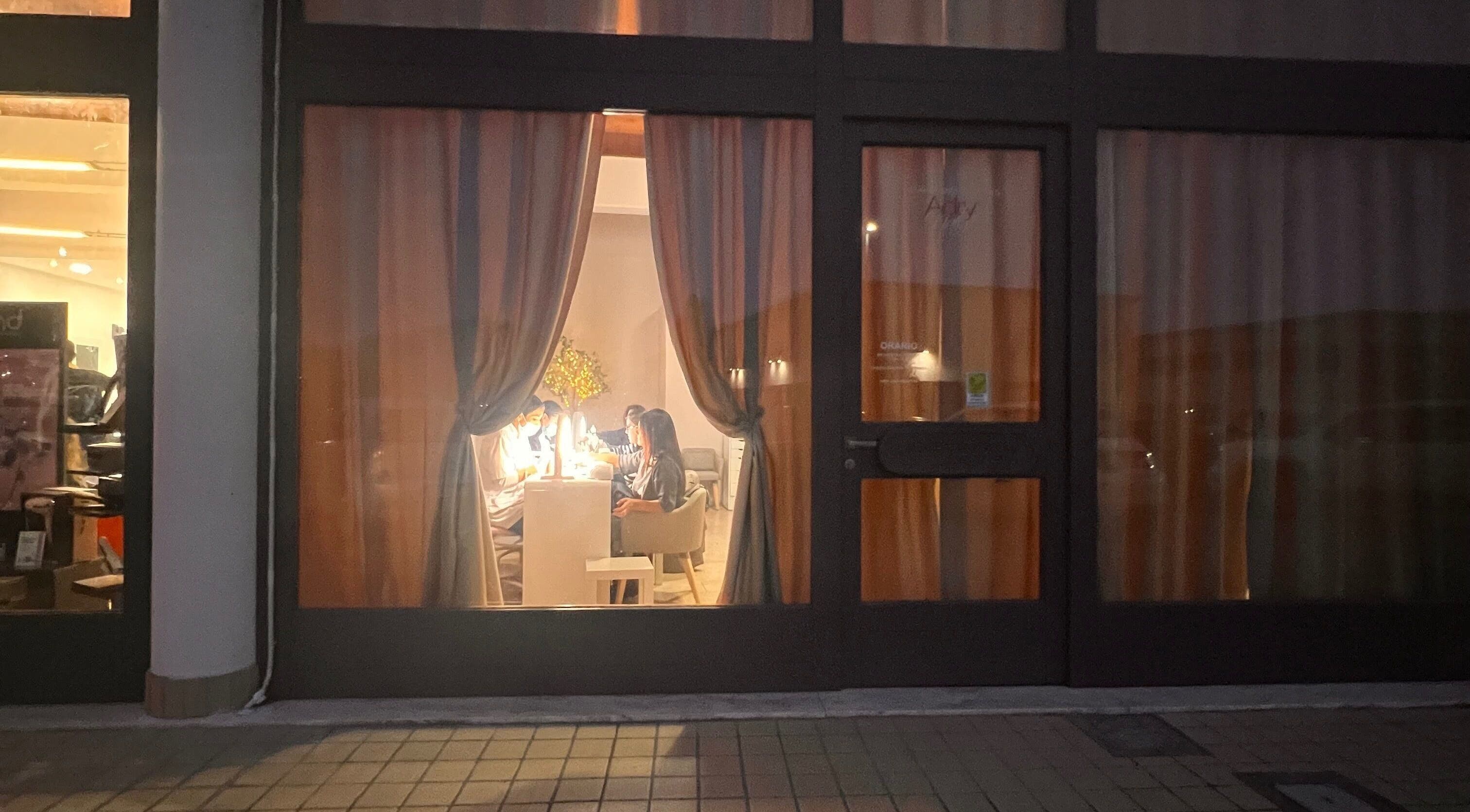 Visuale notturna di Adry Nails a L'aquila, Abruzzo, IT, con clienti all'interno.