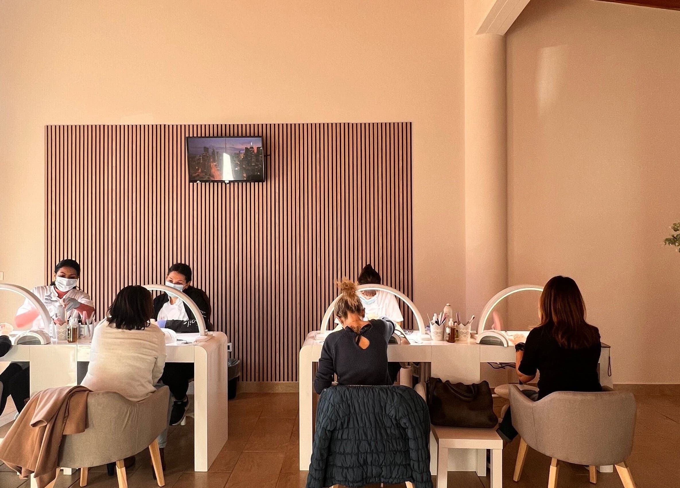 Interno elegante di Adry Nails a L'Aquila, Abruzzo, IT, con clienti e tecnici al lavoro.