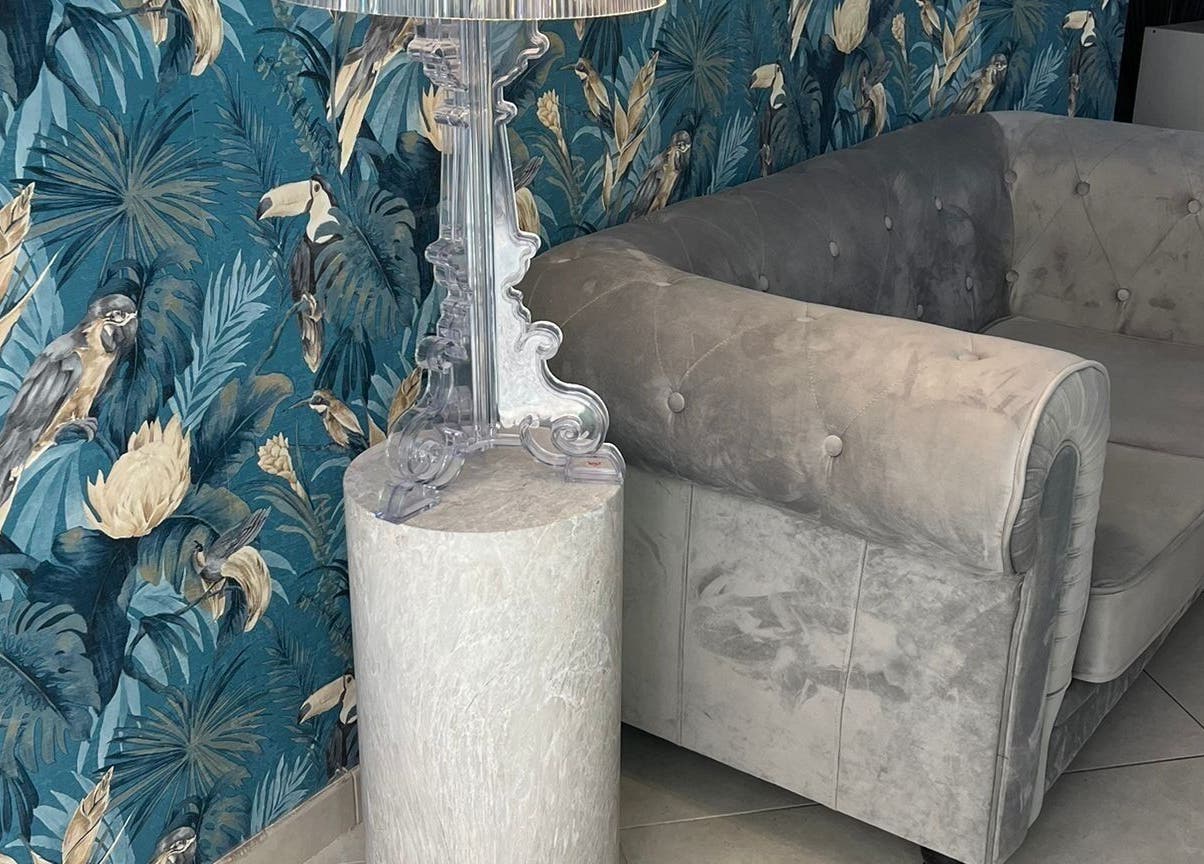 Interno accogliente di Adry Nails Centro a L'aquila, Abruzzo, IT con divano elegante e carta da parati tropicale.