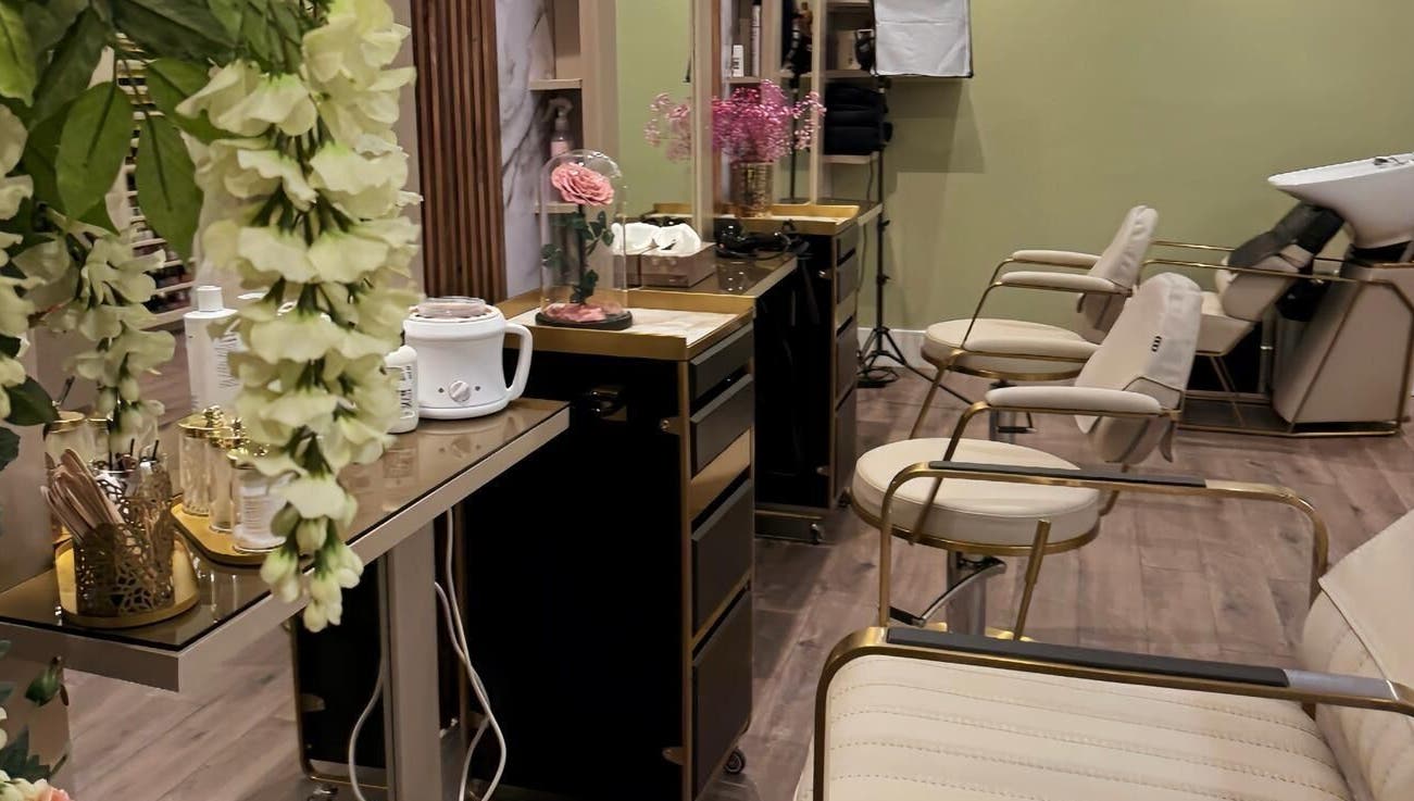 Chic salon interior at Enhance Angel Hair & Beauty, London, England, GB, featuring plush seating and floral decor.