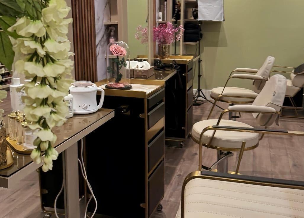 Chic salon interior at Enhance Angel Hair & Beauty, London, England, GB, featuring plush seating and floral decor.