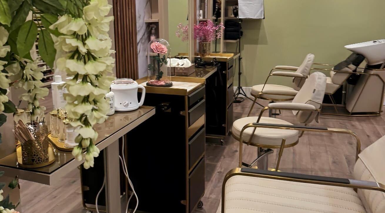 Chic salon interior at Enhance Angel Hair & Beauty, London, England, GB, featuring plush seating and floral decor.