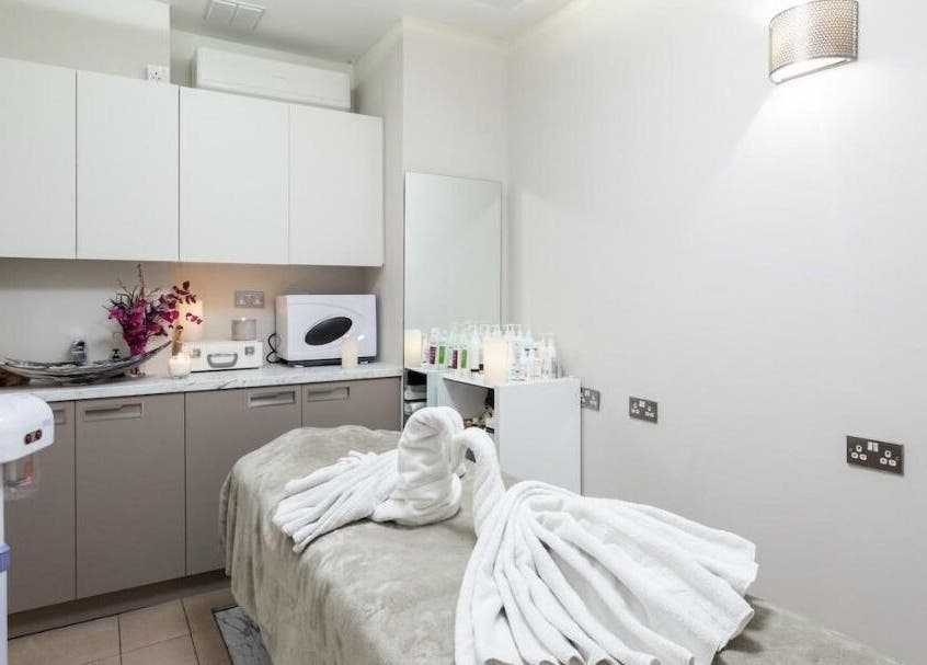 Relaxing treatment room at Enhance Angel Hair & Beauty, London, England, GB with neatly arranged towels.