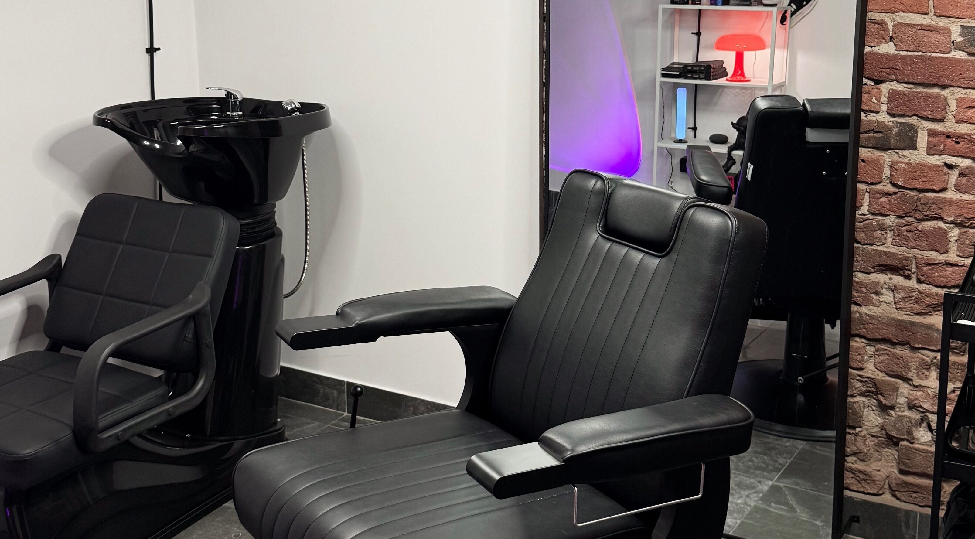 Modern barber chair at Barber.Mo in Łódź, Województwo Łódzkie, PL featuring sleek black design.