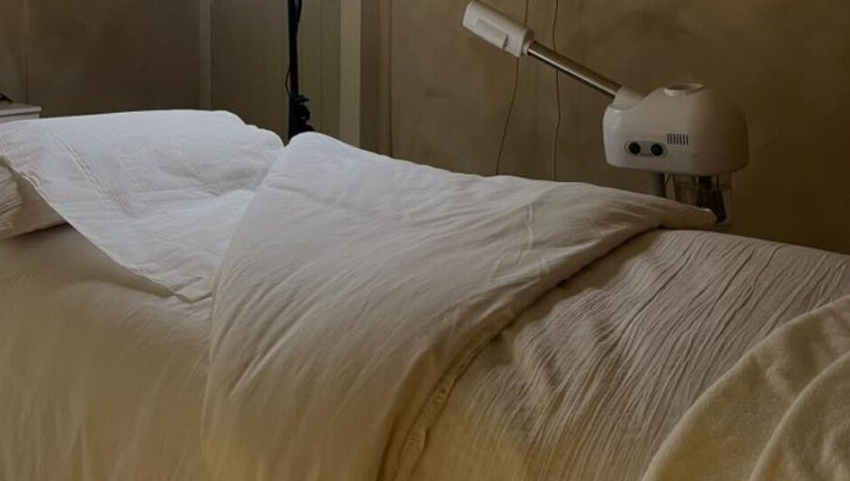 Cozy treatment bed at Surya Skin + Wellness, Reigate, England, GB, creates a serene, welcoming atmosphere for clients.