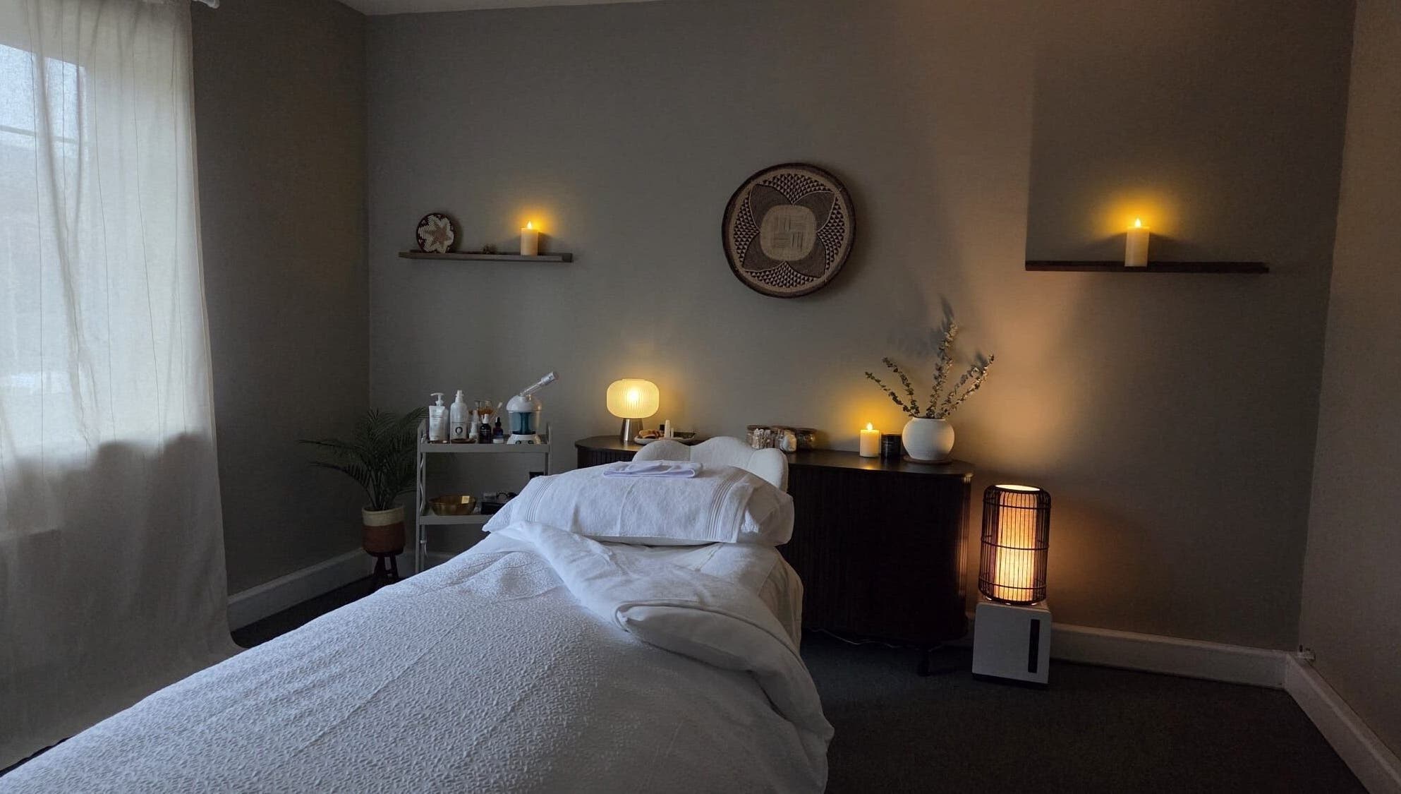Peaceful treatment room at Surya Skin + Wellness, Reigate, England, GB, with warm lighting and soothing decor.