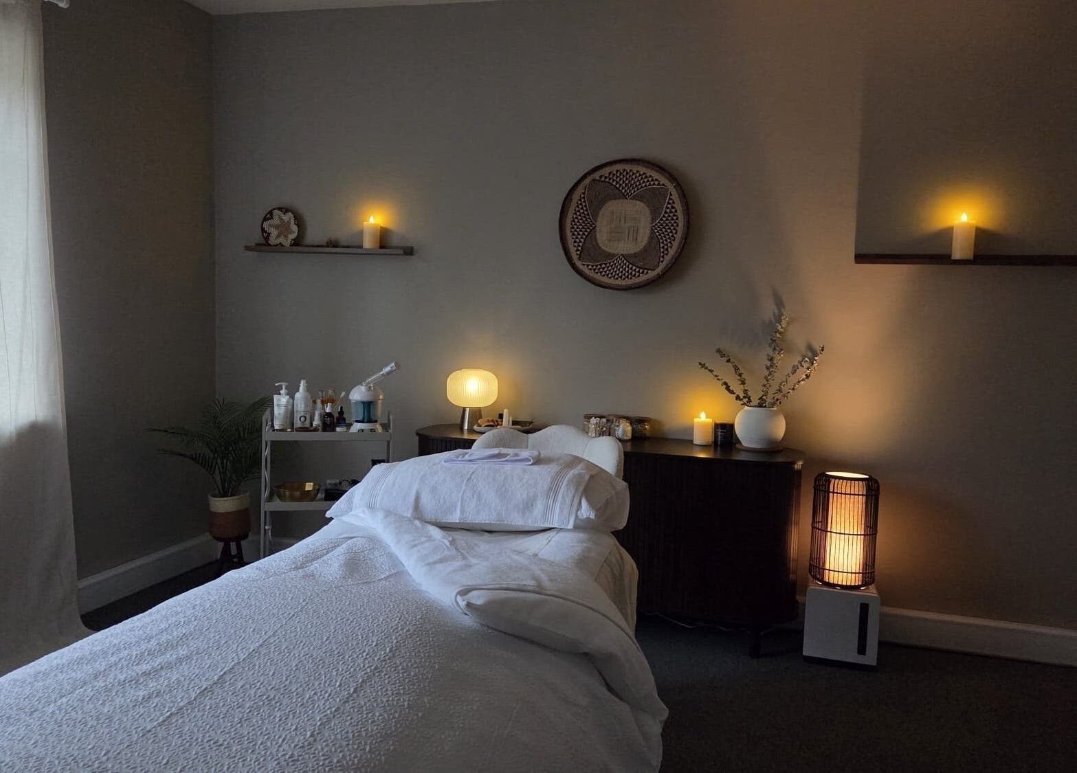 Peaceful treatment room at Surya Skin + Wellness, Reigate, England, GB, with warm lighting and soothing decor.