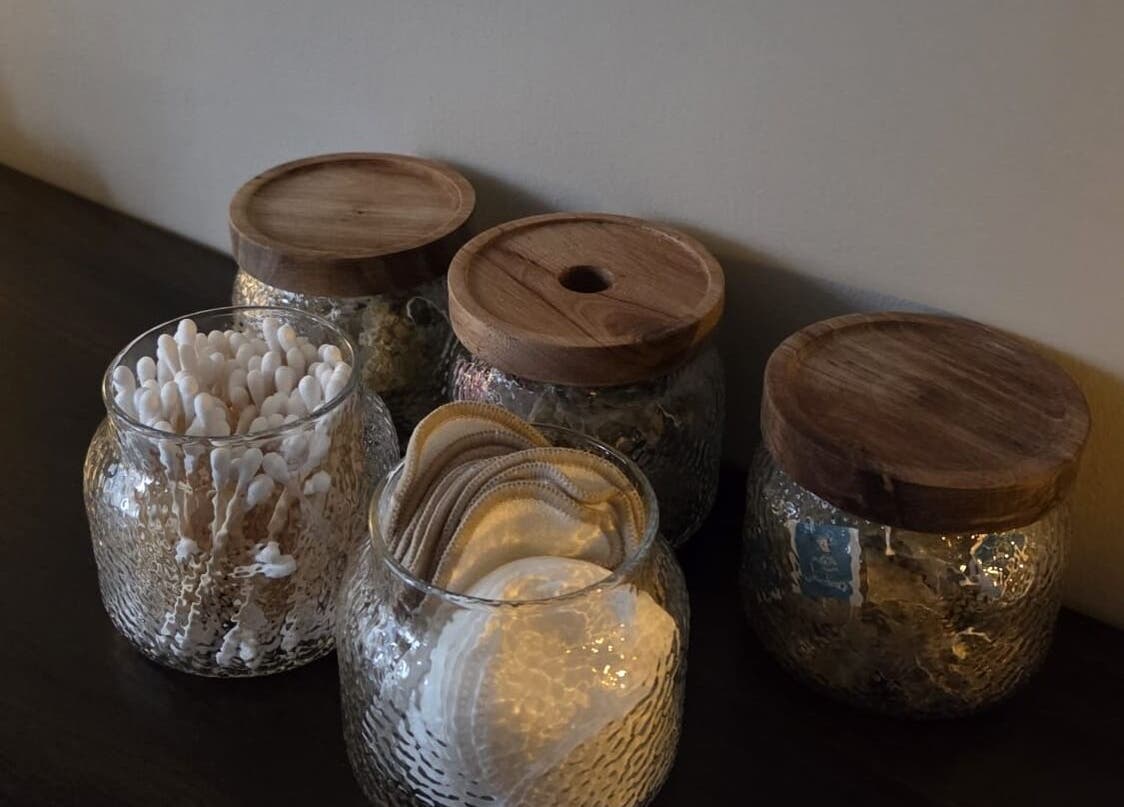 Stylish glass jars with natural wooden lids at Surya Skin + Wellness, Reigate, England, GB.