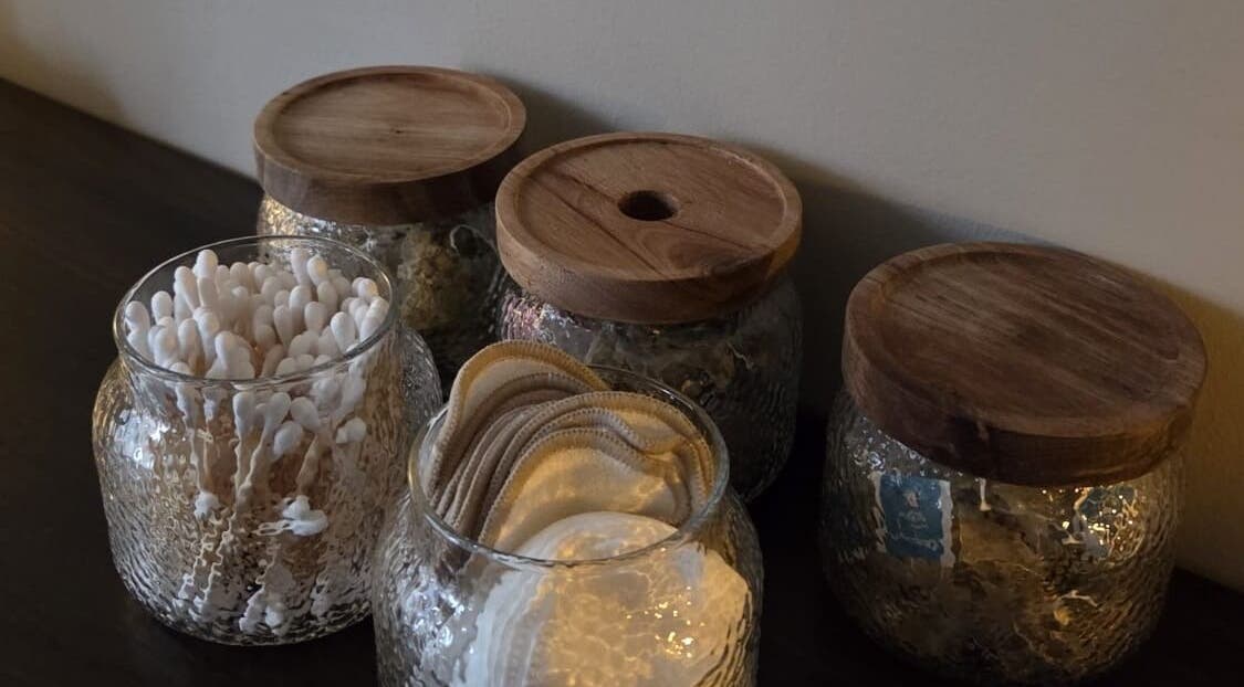 Stylish glass jars with natural wooden lids at Surya Skin + Wellness, Reigate, England, GB.