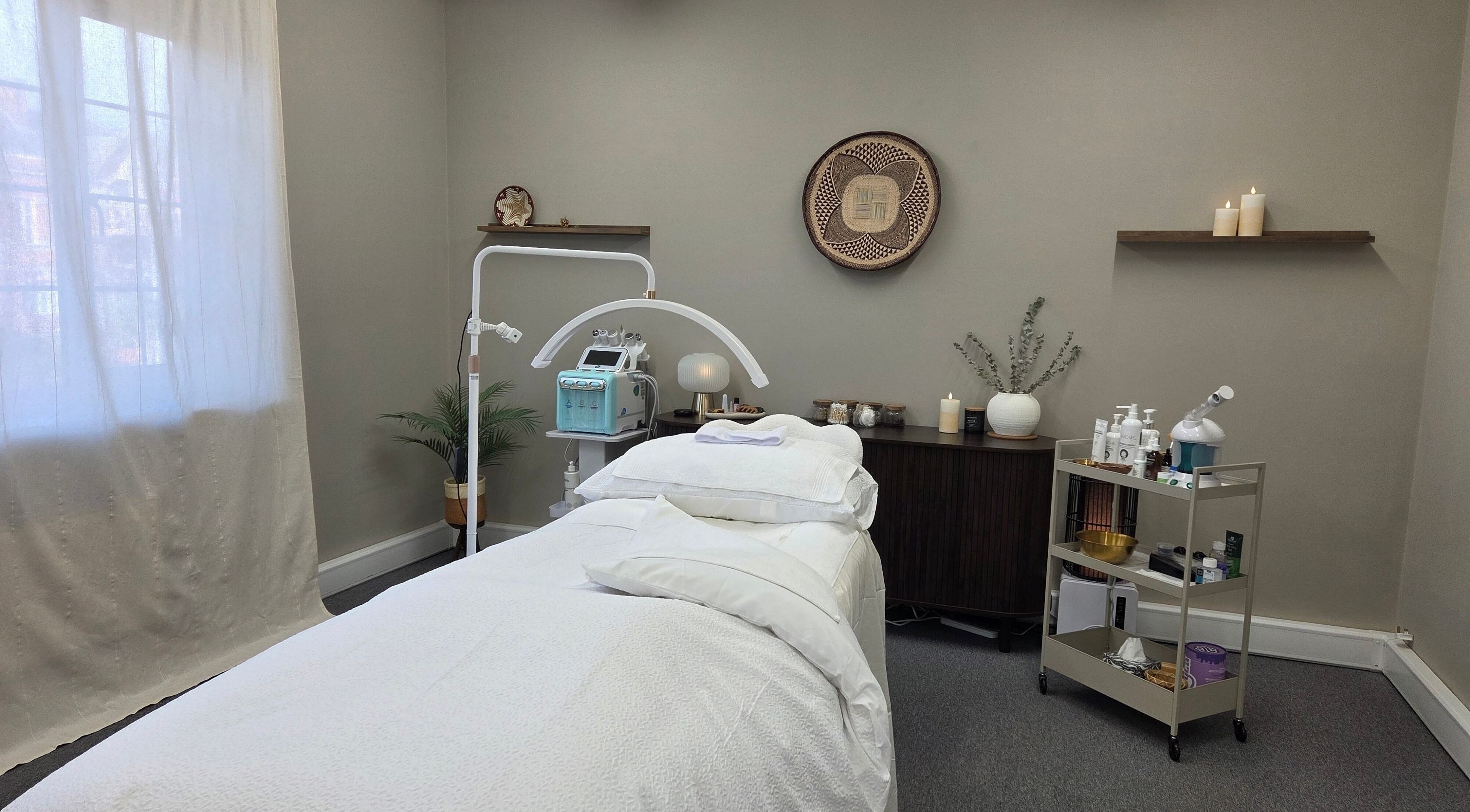 Elegant treatment room at Surya Skin Wellness, Reigate, England, GB, featuring a serene massage table and soft lighting.