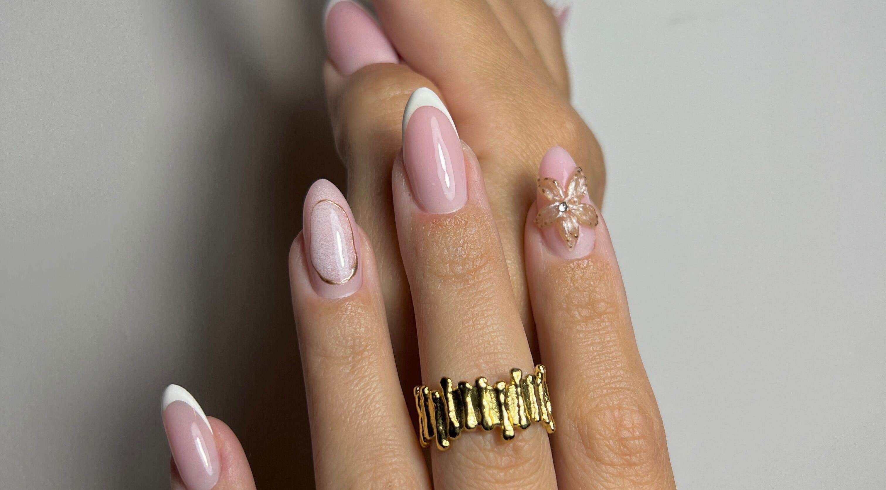 Elegant floral nail art at Karina Nascimento, Tas-sliema, MT, featuring pink hues and gold accents.