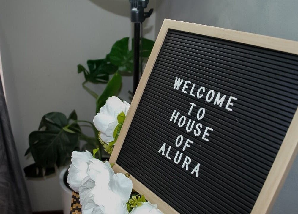 Welcome sign at House Of Alura, Midrand, Gauteng, ZA, adorned with white flowers.