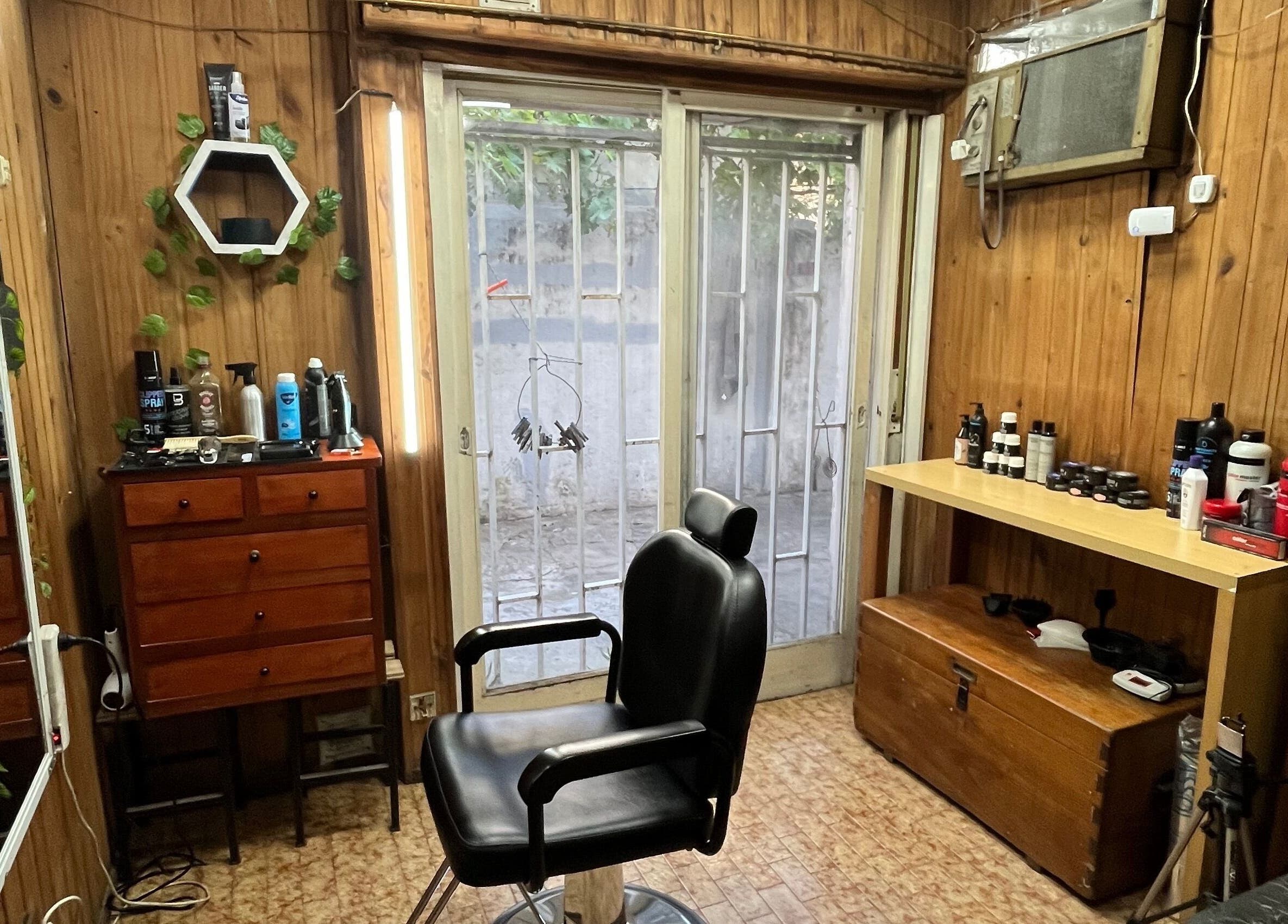 Interior de Galasso Barber Studio, Rosario, Santa Fe, AR. Silla de barbero y productos en exhibición.