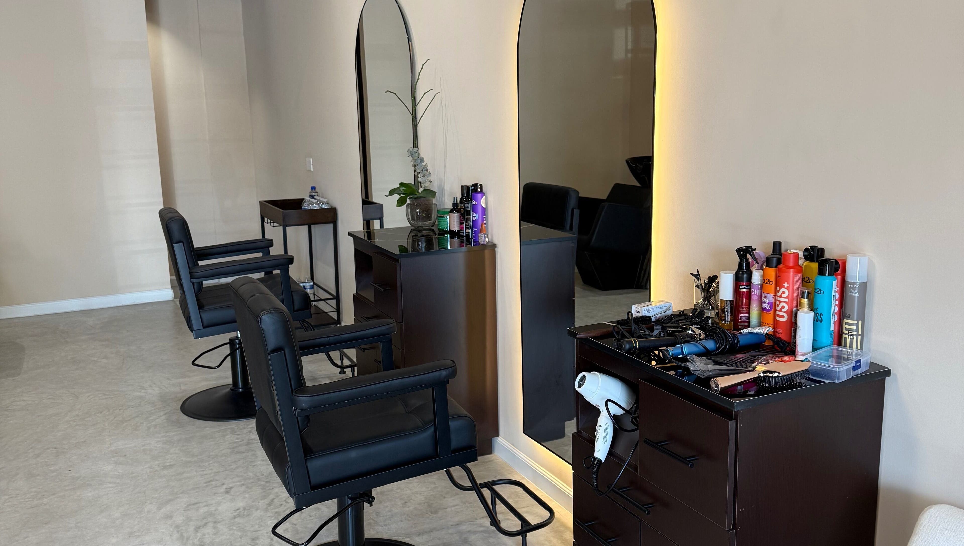 Espacio moderno en Voilá Beauty, San Pedro Garza García, Nuevo León, MX con sillas y productos de belleza.