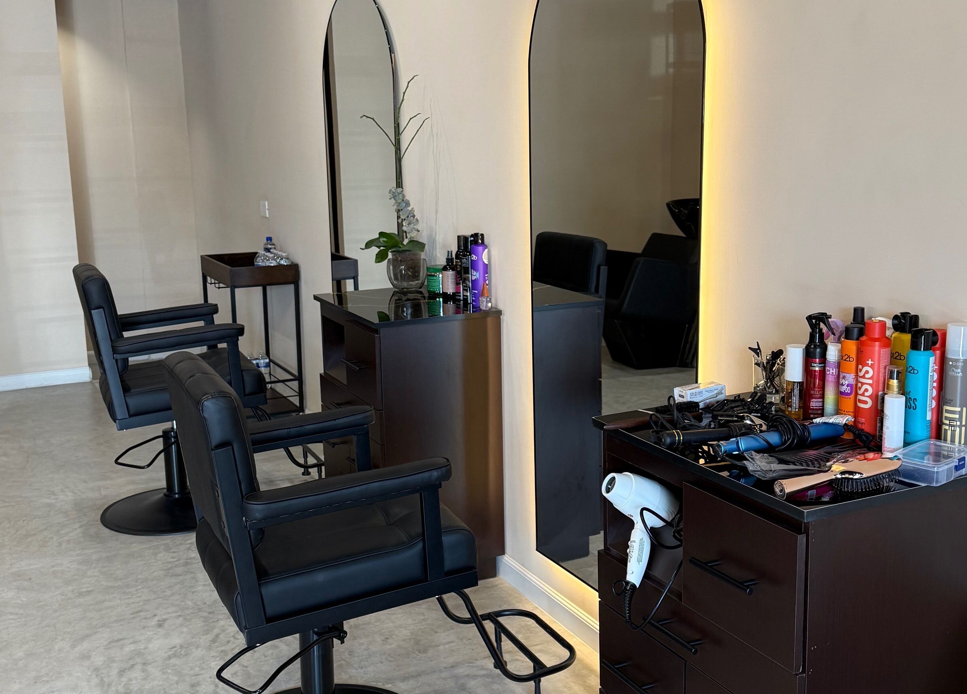 Espacio moderno en Voilá Beauty, San Pedro Garza García, Nuevo León, MX con sillas y productos de belleza.