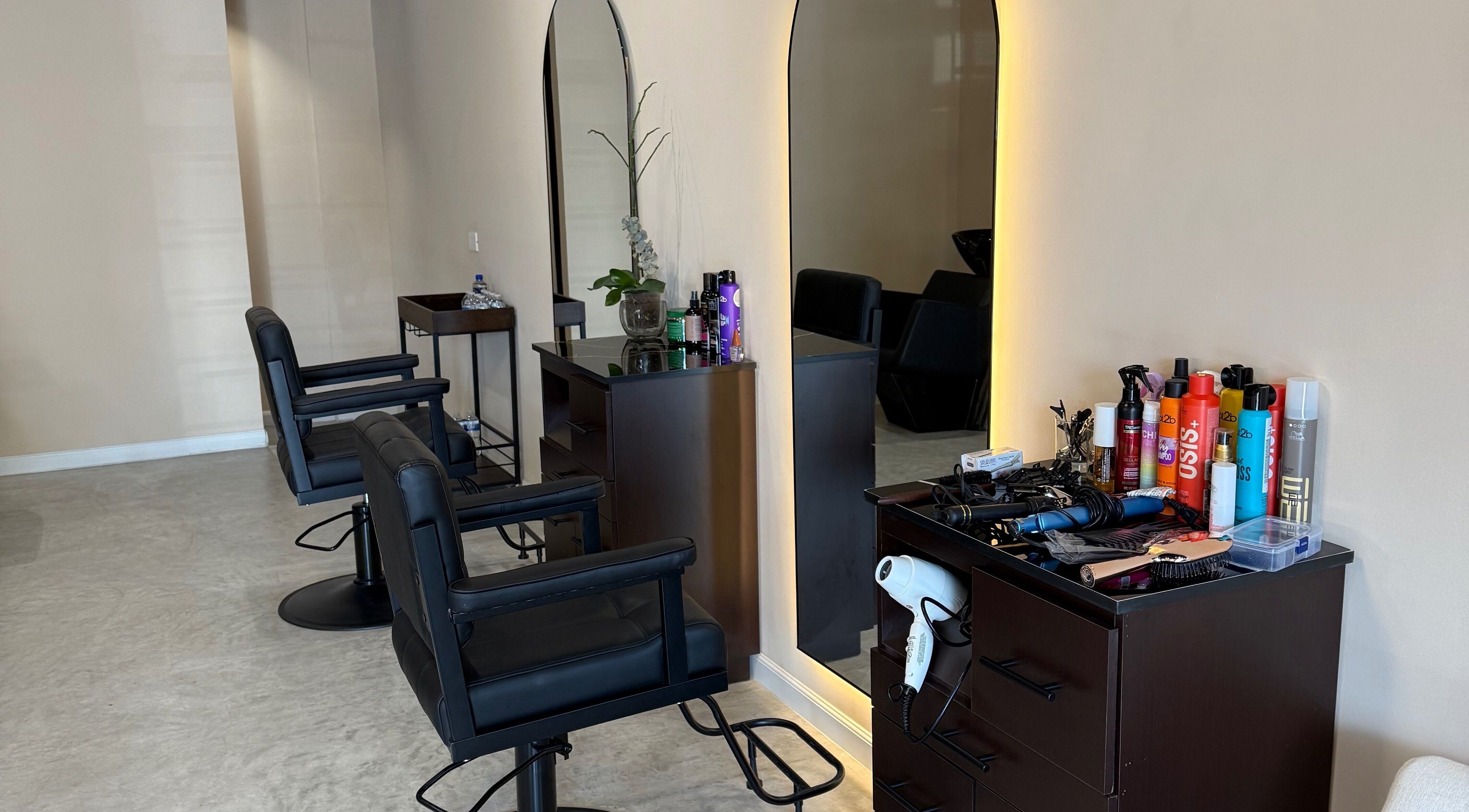 Espacio moderno en Voilá Beauty, San Pedro Garza García, Nuevo León, MX con sillas y productos de belleza.