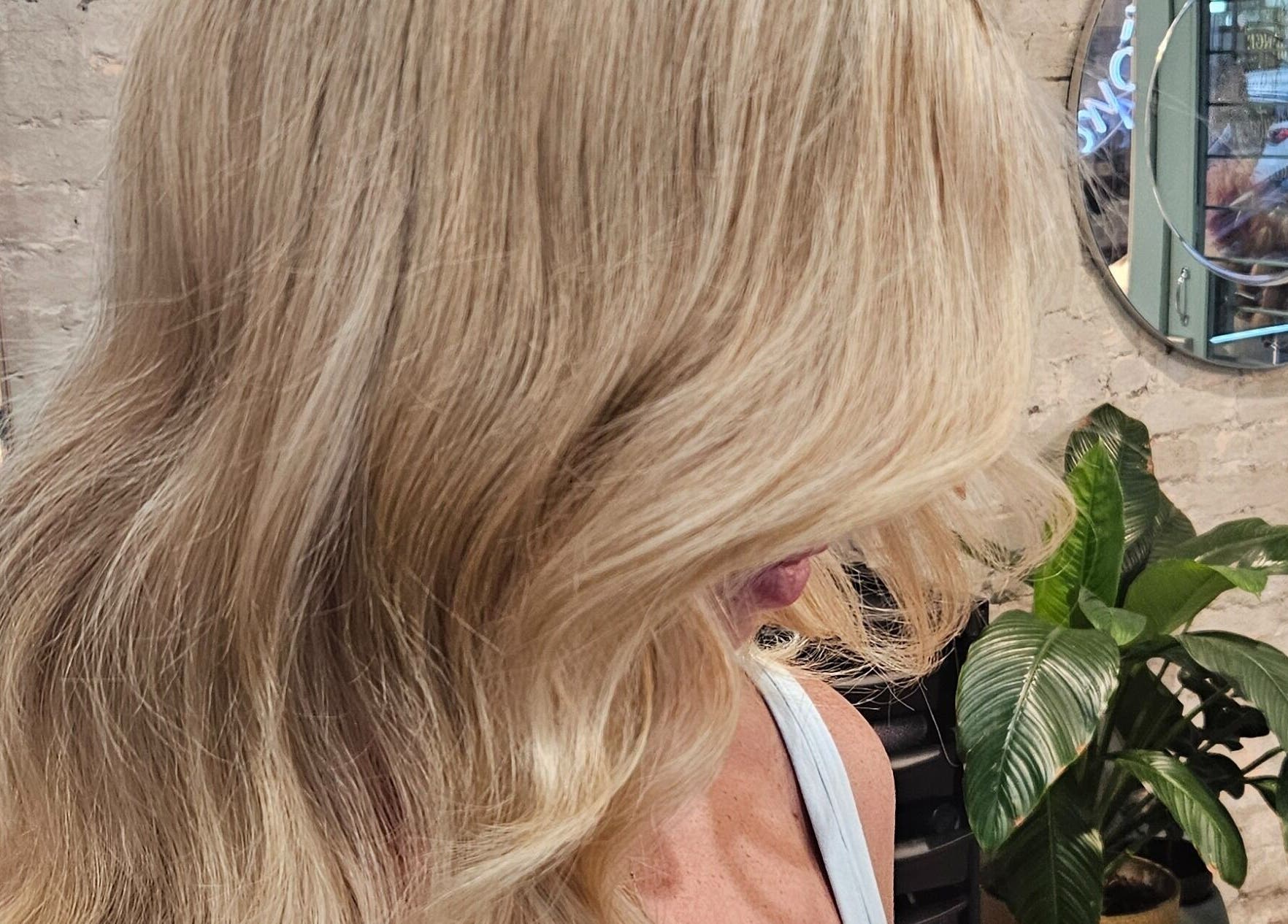 Elegant blonde hairstyle at Movement Not Just Hair in Surry Hills, New South Wales, AU with mirror backdrop.
