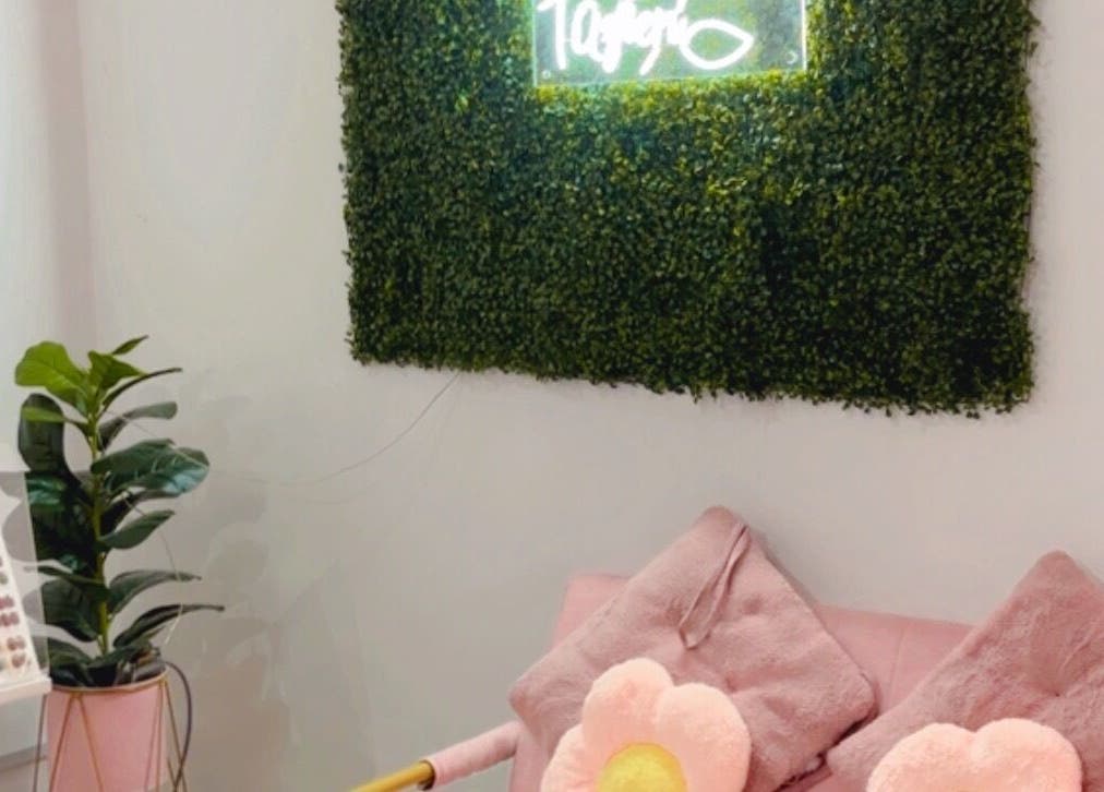 Cozy seating at Ruang Spa Azren in Kuala Lumpur, MY with floral cushions and lush greenery.