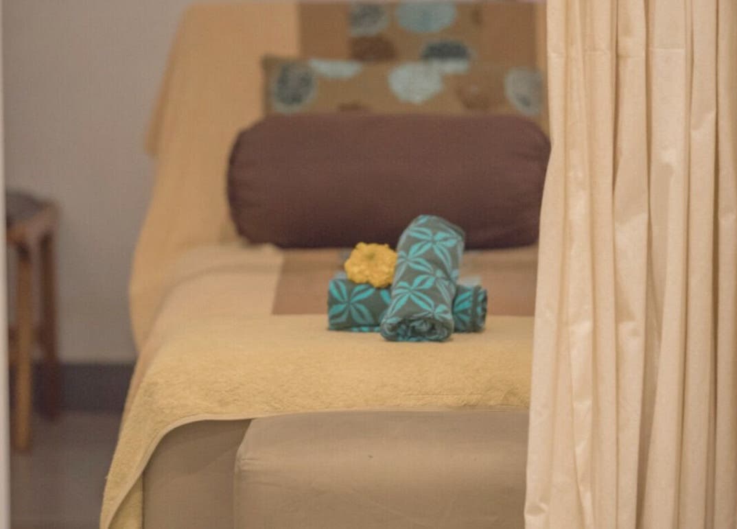 Cozy spa room at Aliya Wellness Spa in Bali, Bali, ID with towels and floral accents.