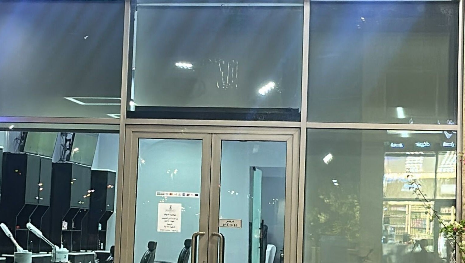 Entrance of AJ barbershop in Jeddah, Makkah Province, SA featuring a modern glass facade.