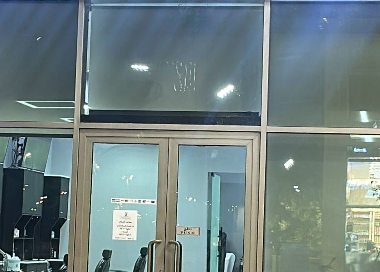 Entrance of AJ barbershop in Jeddah, Makkah Province, SA featuring a modern glass facade.