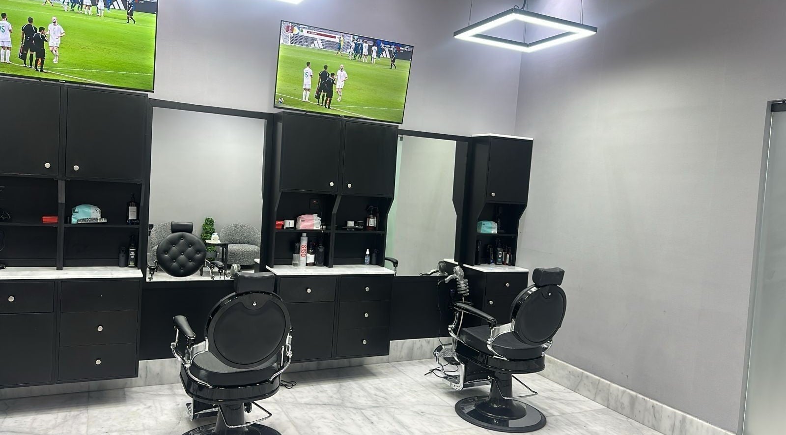 Interior of AJ barbershop in Jeddah, Makkah Province, SA, showcasing a modern barber chair and sleek design.