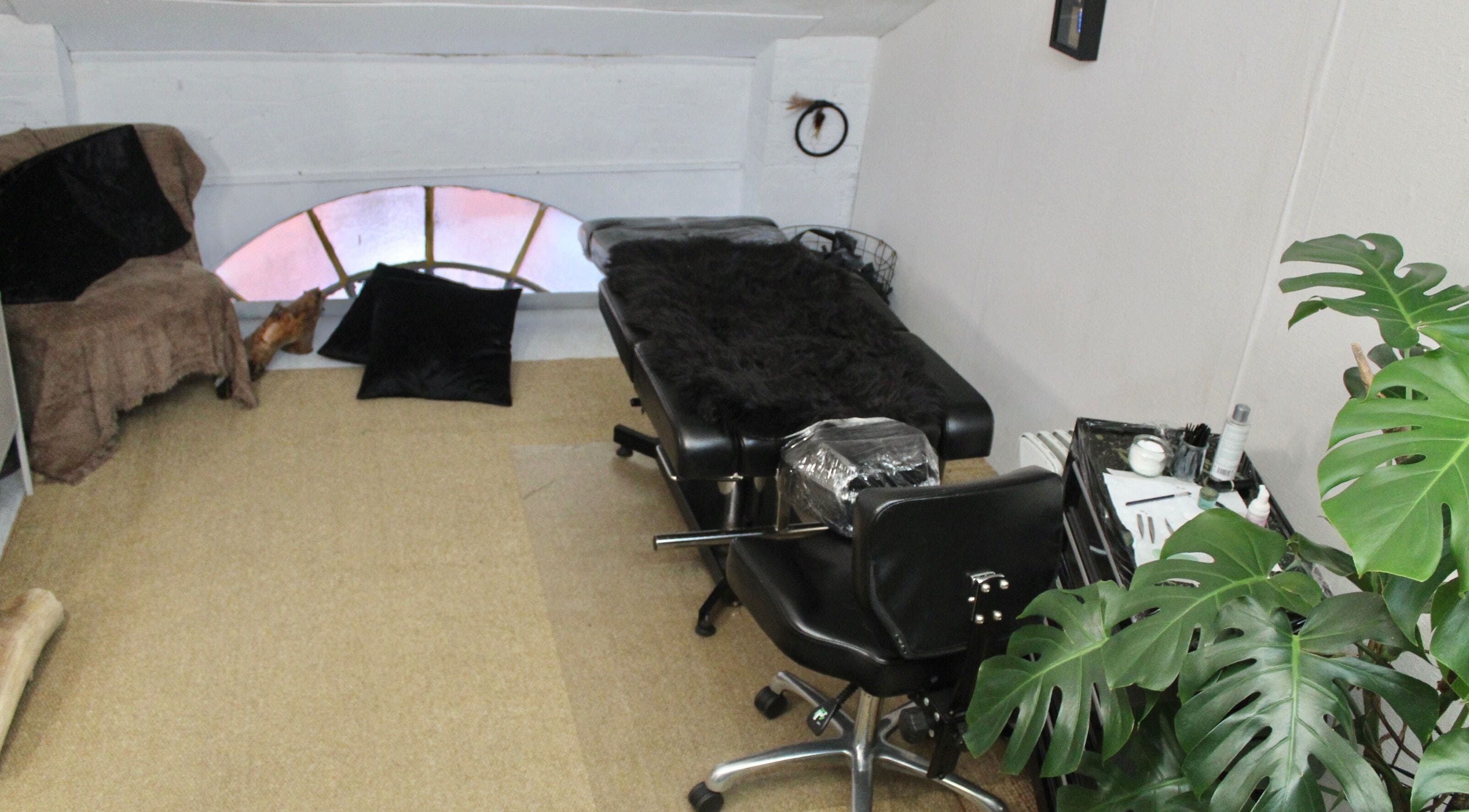Chic treatment room at Lainey Castro Brow Artist, Dublin, County Dublin, IE. Features black chair and lush plant.