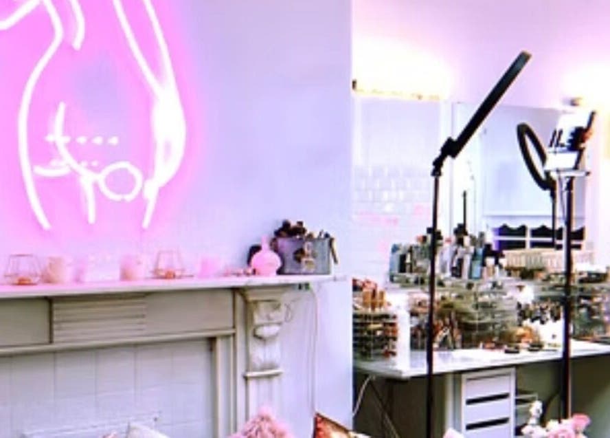 Makeupbykian studio in Liverpool, England, GB, showcasing a chic pink neon sign and modern makeup setups.