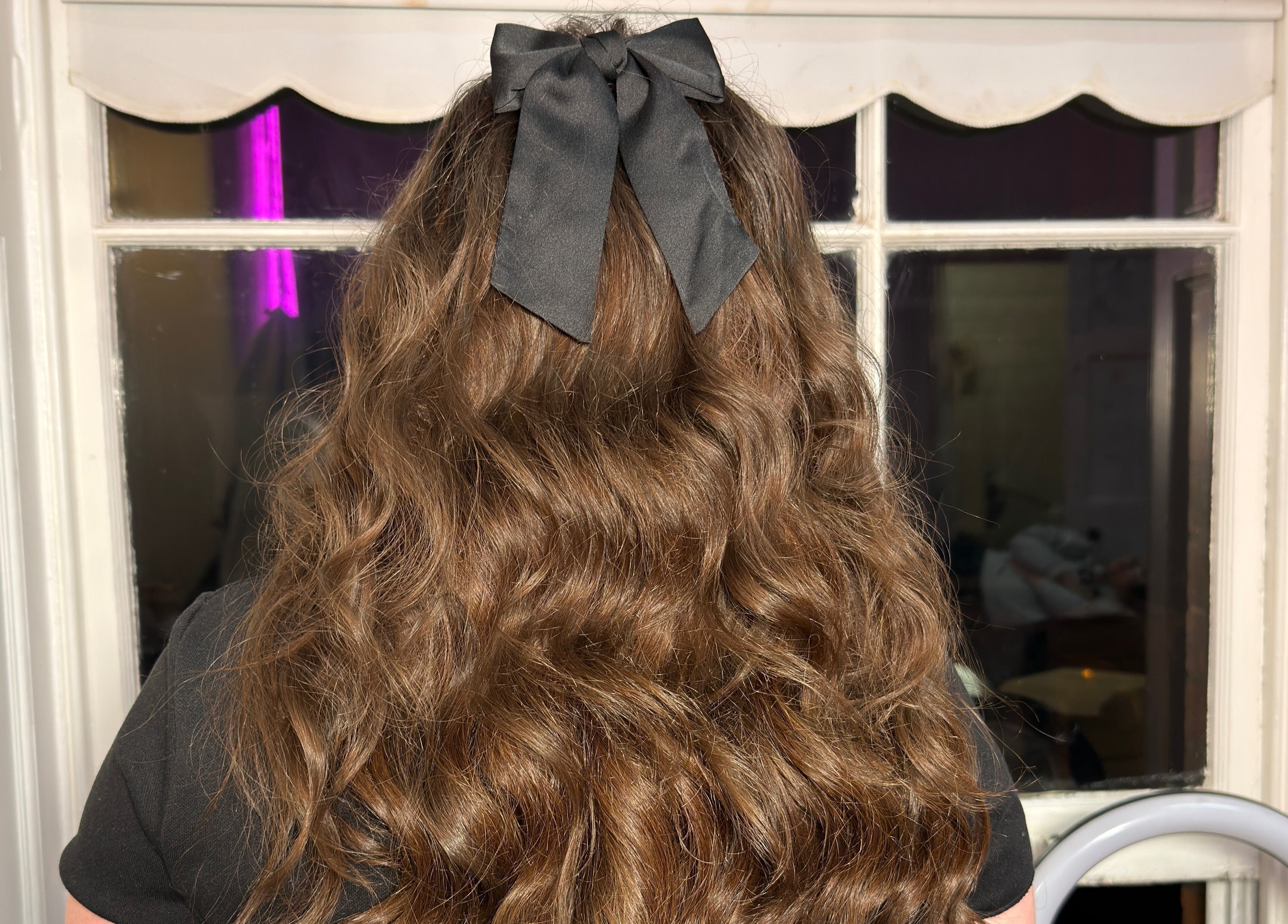 Stylish wavy hair with a black bow at Makeupbykian, Liverpool, England, GB.