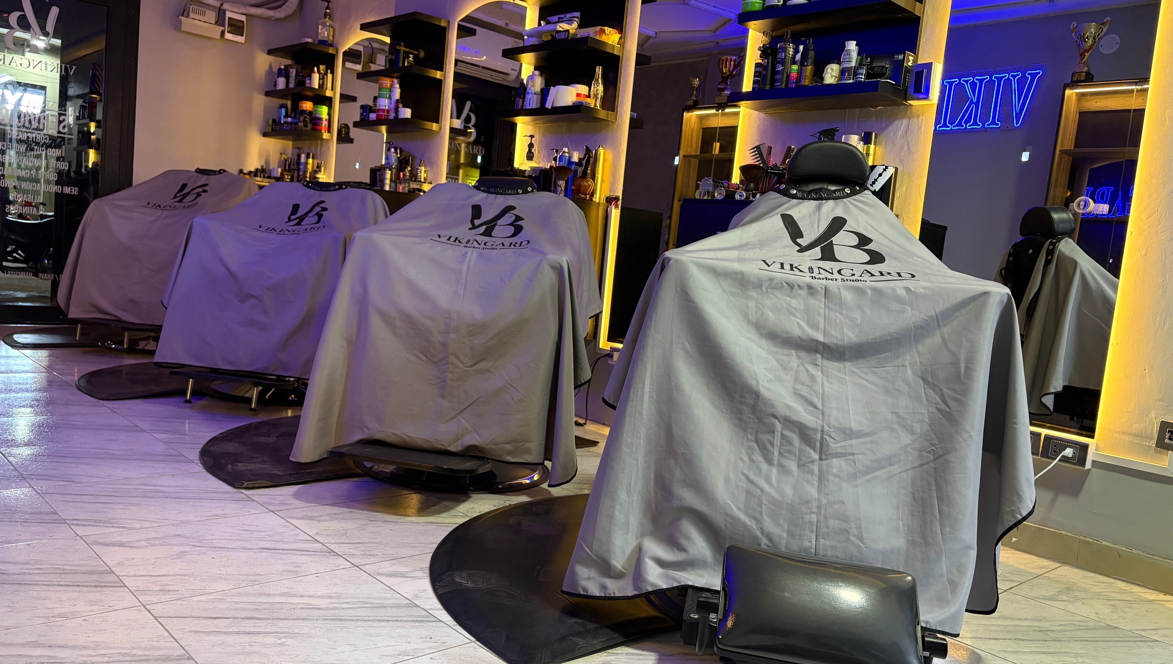 Interior moderno de VIKINGARD BARBER STUDIO en Chiclayo, Lambayeque, PE, con sillas elegantes y ambiente acogedor.