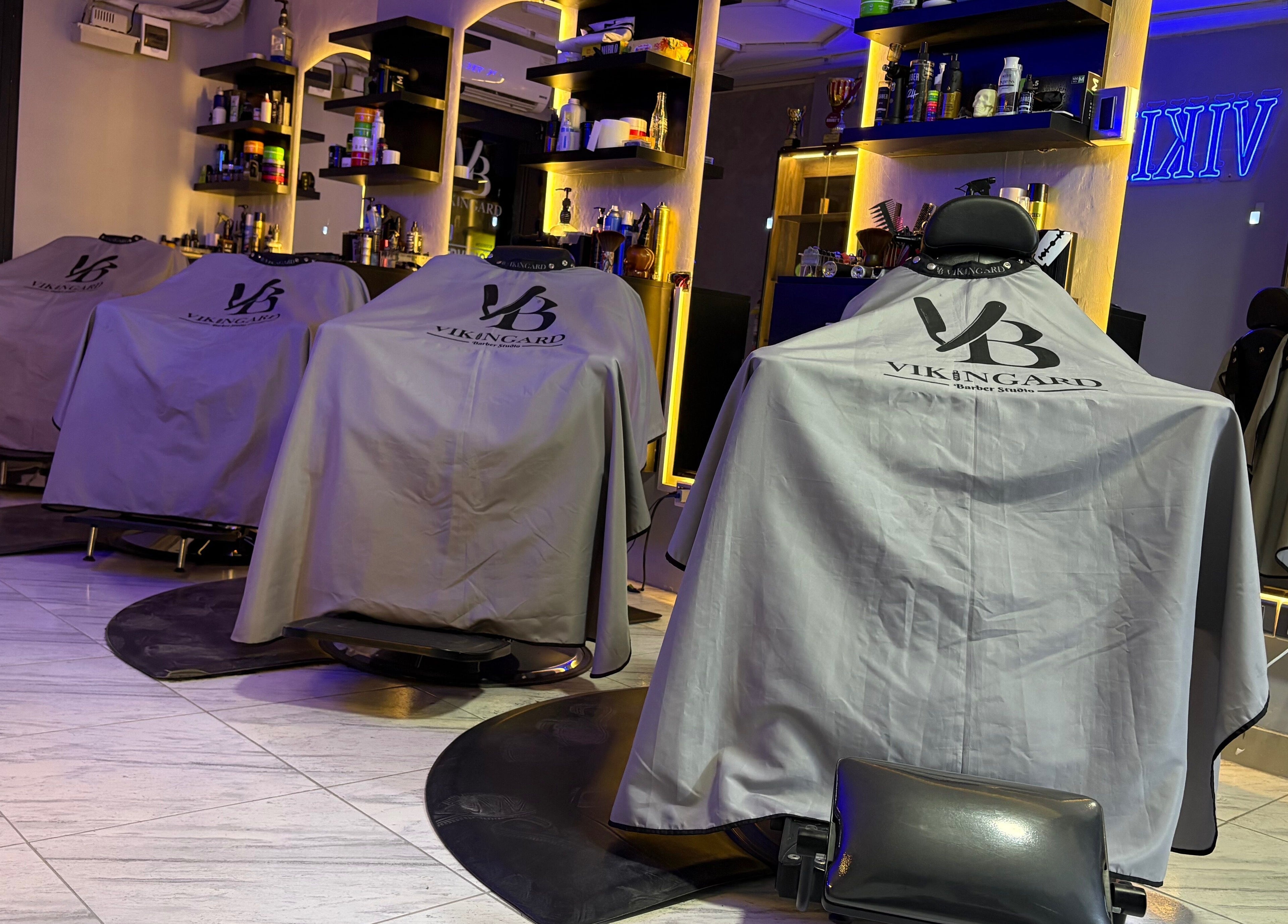 Interior moderno de VIKINGARD BARBER STUDIO en Chiclayo, Lambayeque, PE, con sillas elegantes y ambiente acogedor.