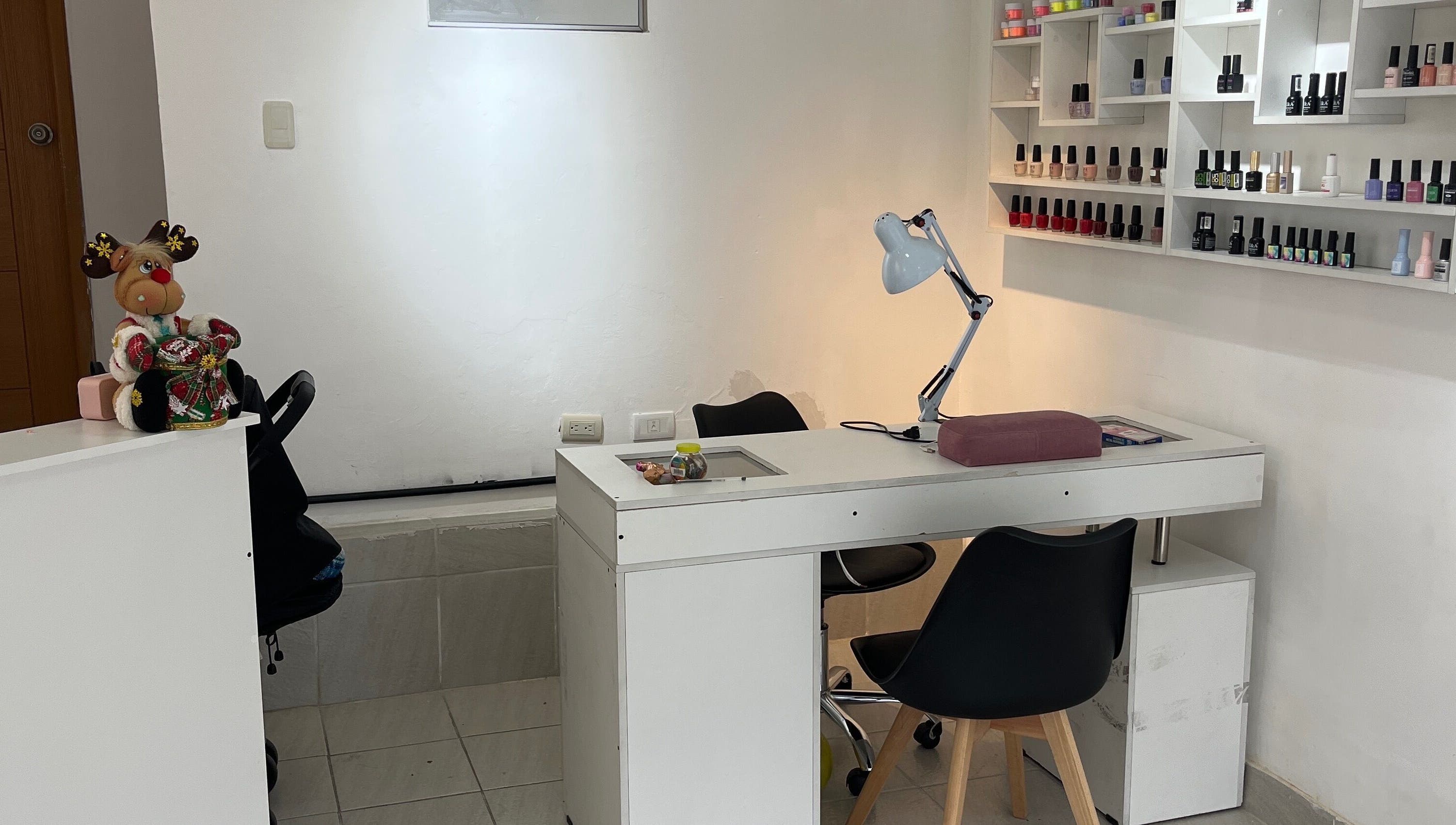 Mesa de manicure en DANIELA BEAUTY CONCEPT, Quito, Pichincha, EC, con esmaltes en exhibición.