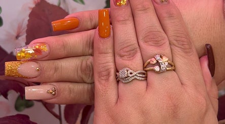 Autumn-themed nail art at Nailsbyflor, New York, New York, US. Features orange and gold design with leaf accents.
