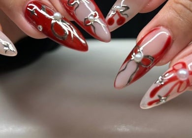 Elegant red and pearl nail art at Nailsbyflor, New York, New York, US, featuring intricate designs.
