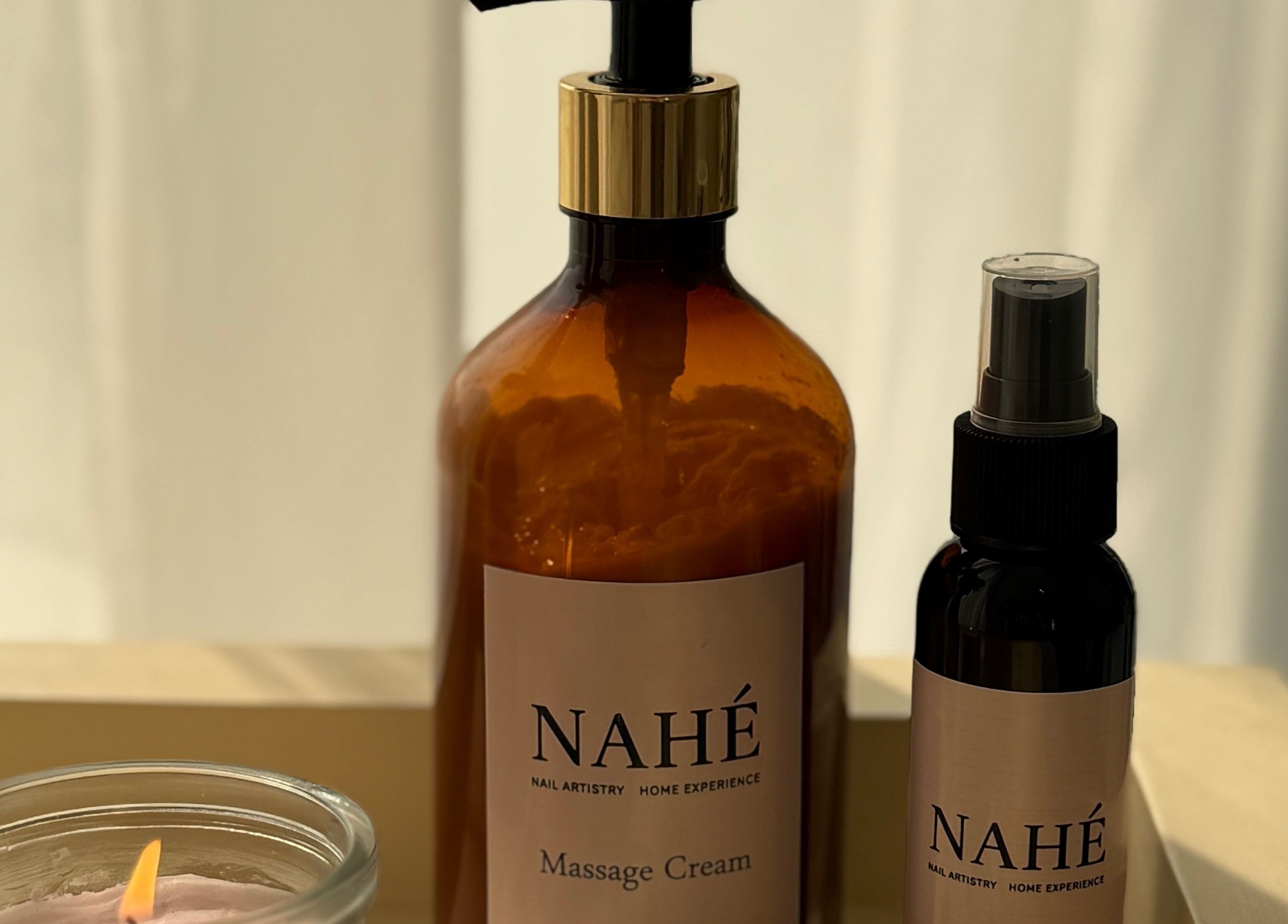 Nahé Beauty Home Service Salon products on display in Dubai, AE with candle and massage cream.