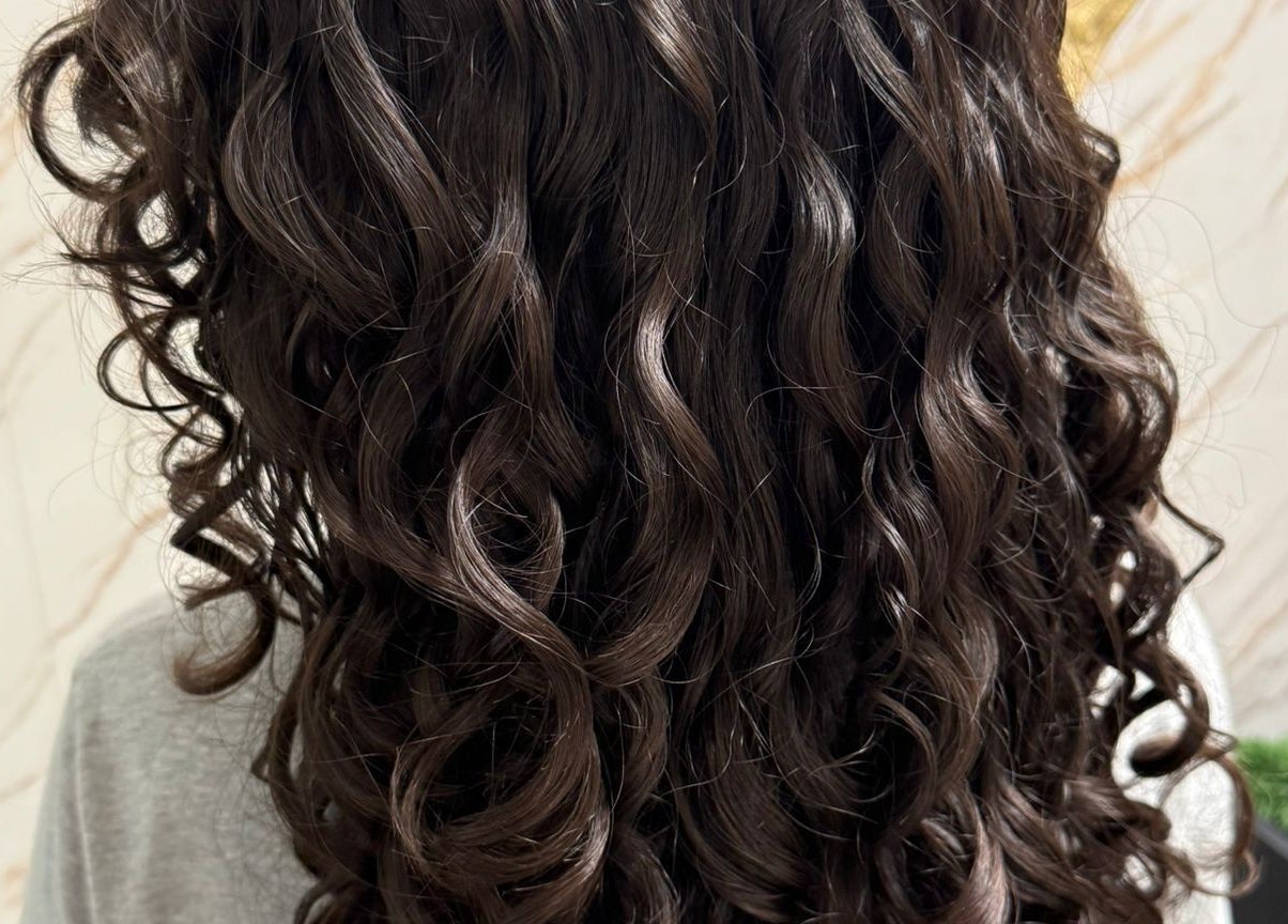 Cabello rizado oscuro en Ador Curl, Caguas, Caguas, PR, destacando estilo saludable y brillante.