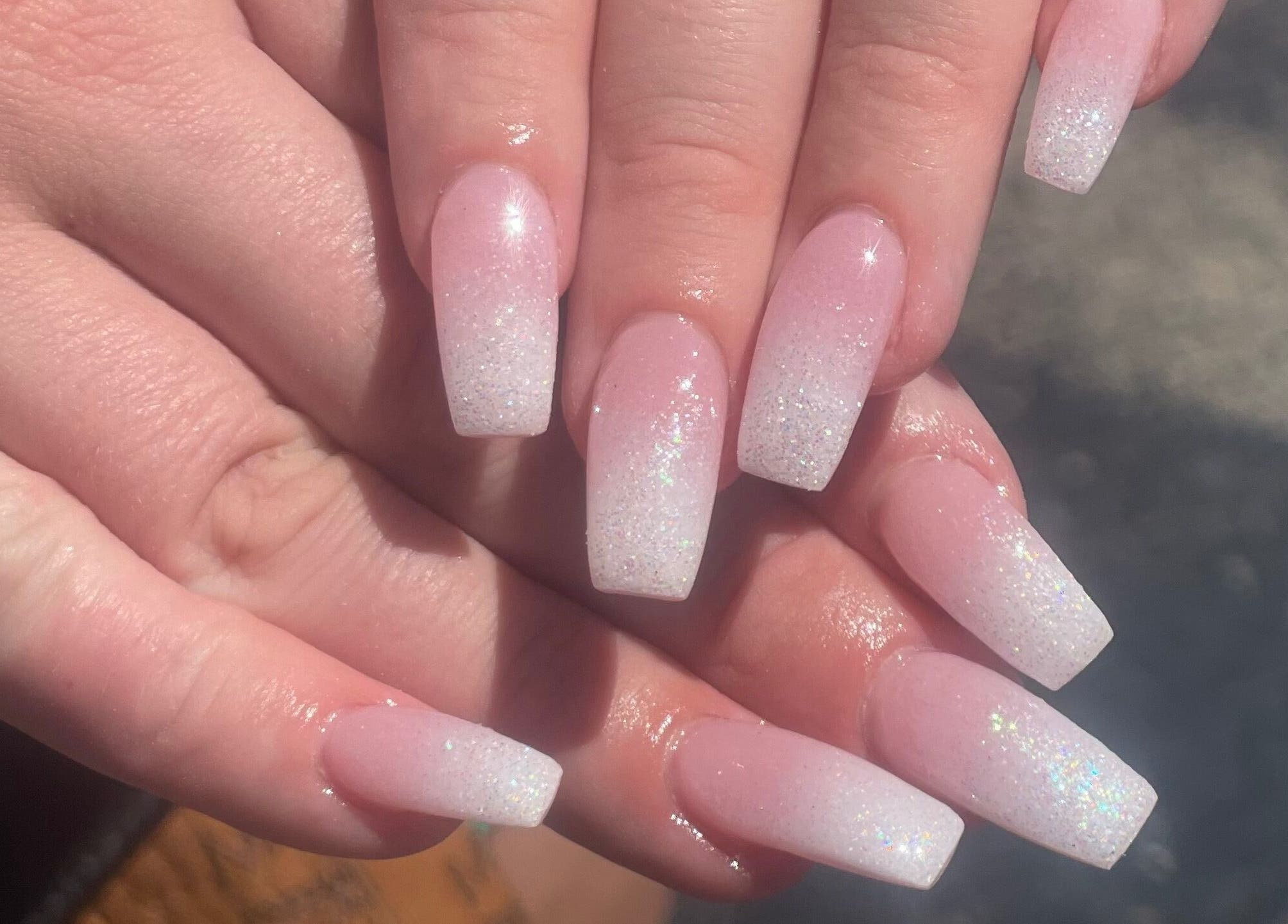 Glittery pink ombre nails from Glimmer Nail Studio in Oshkosh, Wisconsin, US, showcasing expert nail art.