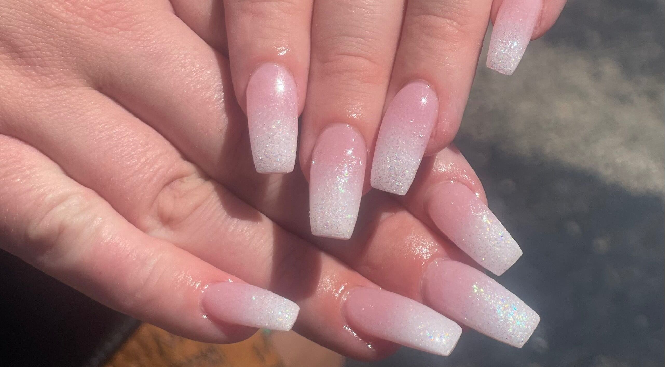 Glittery pink ombre nails from Glimmer Nail Studio in Oshkosh, Wisconsin, US, showcasing expert nail art.